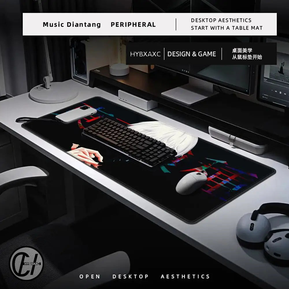 Computer desk setup with a large mouse pad, keyboard, and monitor on a dark surface.