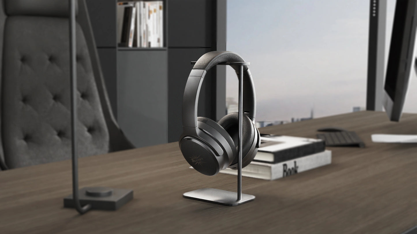 Black headphones on a stand in an office setting with books and a cityscape view.